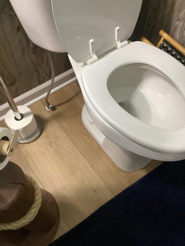 Inspected and assessed main drain stack system from basement level through first floor toilet connection. Previous evaluation covered lower section of stack only; expanded scope to include upper portion at first floor toilet elbow junction. Documented condition of white PVC drain line where it emerges through ceiling in lower level, noting curved elbow section and connection points. Examined first floor toilet installation and drain connection to verify proper tie-in to main stack. Photographed exposed plumbing runs, structural penetrations, and toilet fixture to document existing conditions for recommended repair work on compromised stack section.