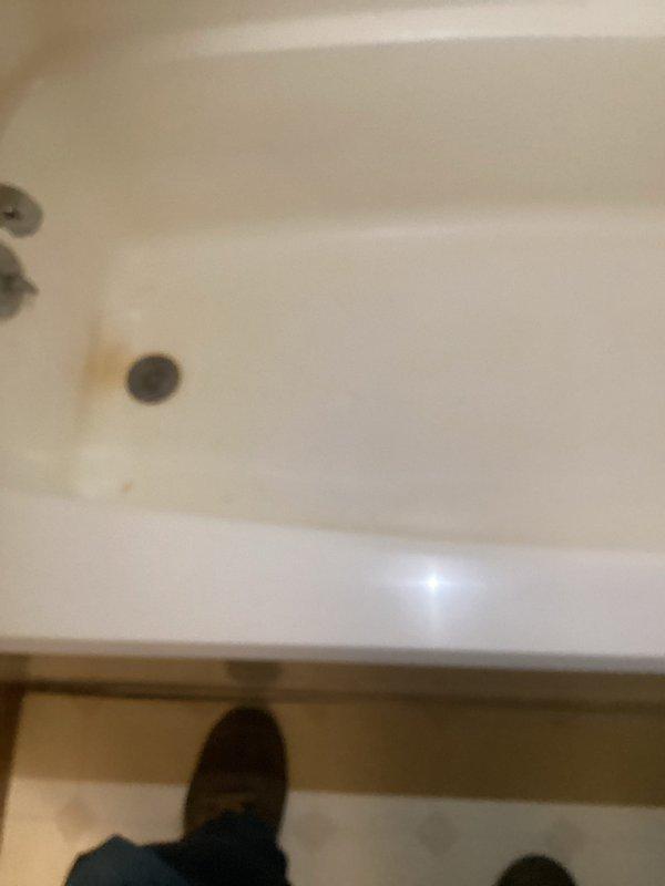 Responded to emergency water leak causing active damage to kitchen ceiling below upstairs bathroom. Upon arrival, inspected bathroom fixtures and identified source of leak at bathtub drain assembly with failed seal allowing water penetration through subfloor. Removed existing drain components, cleaned surfaces of mineral deposits and debris, and installed new drain gasket and tightened connections to manufacturer specifications. Conducted water flow test to verify repair integrity and confirmed no further leakage. Advised that kitchen ceiling drywall repair will be required once affected area has adequately dried, with recommendation to monitor for 24-48 hours before proceeding with restoration work.