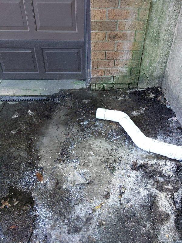 Repaired a 4-inch drainage system penetrating through a retaining wall using PVC pipe and fittings to redirect water flow toward the trough drain located at the garage door entrance. Removed deteriorated concrete sections around the affected area to facilitate proper drainage installation and eliminate standing water that had caused extensive moisture damage, algae growth, and surface deterioration on both the concrete floor and adjacent brick masonry.