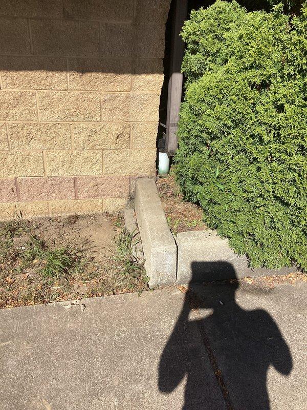 Responded to drainage backup issue where downspouts were overflowing into underground drain system. Upon arrival, inspected exterior drainage components and documented existing conditions including utility markings and concrete surface deterioration near the affected drain area. Assessed downspout connection points and underground drainage infrastructure to identify blockage source and verify proper water flow capacity.