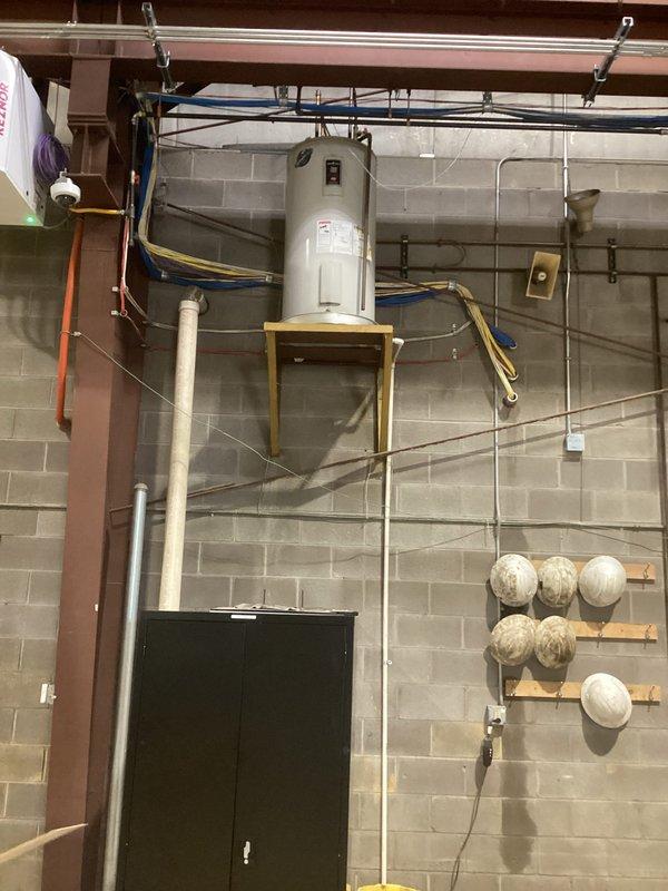 Responded to a leaking commercial electric tank water heater mounted on a wall-mounted shelf bracket, inspected the unit, and addressed the leak to restore safe operation. Verified the installation, connections, and surrounding area were secure and free of active leaks upon completion.