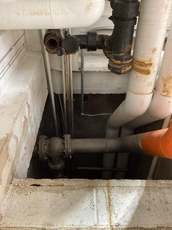 Inspected the drain system serving the floor drain and dishwasher lines and found the cast iron drain piping to be heavily corroded and deteriorated, with rust staining and scaling at fittings, joints, and couplings throughout the overhead and below-grade runs. Based on the extent of the corrosion, an estimated 60 feet of 4-inch cast iron drain line and 40 feet of 1.5-inch cast iron branch piping, including the two branch lines serving the floor drain and dishwasher, require replacement to restore reliable drainage. Documented existing conditions with photos and recommended full replacement of the affected piping.