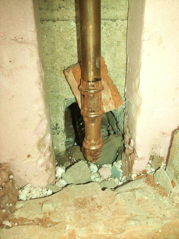 Installed a new outdoor Ecolotrol frost-free faucet by removing interior wall bricks to access the masonry opening and the copper supply line. Connected the copper supply with a press fitting, then mounted the stainless steel wall plate and sealed it into the brick wall with mortar. Used a shop vac to contain dust and debris during the work.