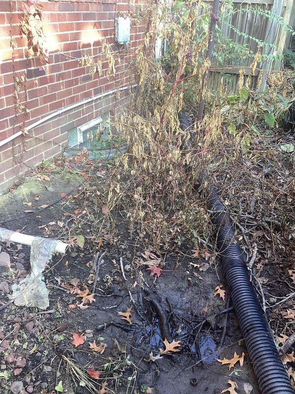 Inspected the exterior sump pump discharge line and found it disconnected from the underground drainage pipe, causing discharge to pool against the foundation. Reconnected and secured the discharge line to the buried drain line, sealing the joint to ensure sump water is properly conveyed away from the structure.