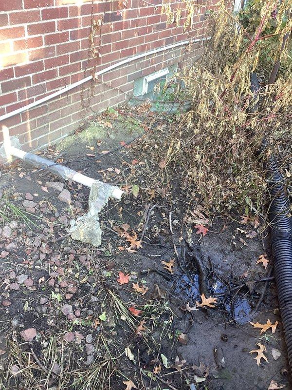 Inspected the exterior sump pump discharge line and found it disconnected from the underground drainage pipe, causing discharge to pool against the foundation. Reconnected and secured the discharge line to the buried drain line, sealing the joint to ensure sump water is properly conveyed away from the structure.