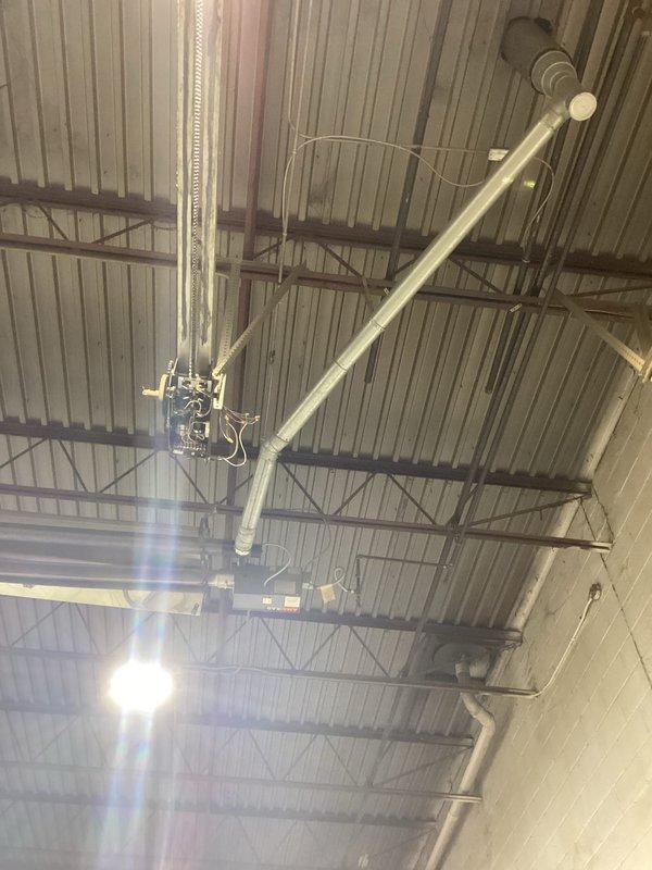 Conducted a comprehensive site assessment for commercial HVAC system installation, documenting the existing ceiling infrastructure which features corrugated metal decking supported by metal beams with various utility pipes and ductwork currently in place. Evaluation included examination of available mounting points, clearance requirements, and integration possibilities with existing cylindrical metal ductwork to determine optimal placement for new system components.