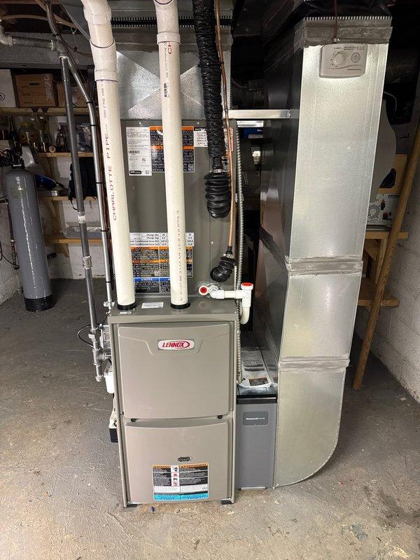 Completed installation of complete HVAC system including Lennox furnace with appropriate ductwork and PVC venting, Lennox air conditioning condenser unit positioned on exterior pad, Ecobee6 smart thermostat, humidifier, and condo pump. System was properly connected and tested for optimal performance with all manufacturer specifications met.