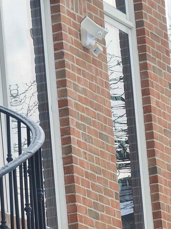 Conducted comprehensive assessment of 30+ year old residential property for complete indoor and outdoor lighting upgrade. Inspected existing exterior motion sensor lighting fixtures mounted on brick facade and evaluated snow-covered walkway areas requiring improved illumination. Documented current electrical panel capacity to determine feasibility of supporting expanded lighting system.