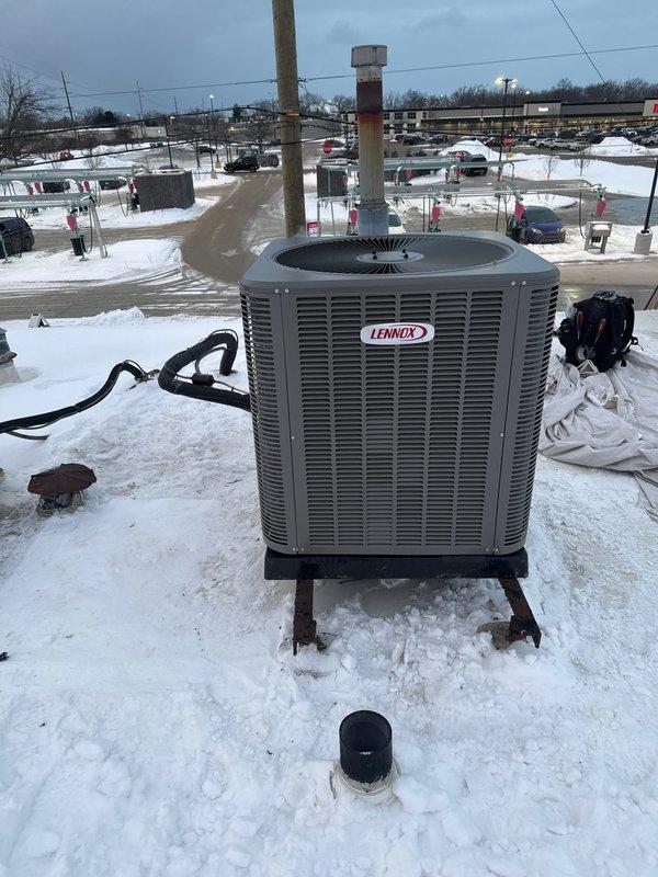 Successfully installed a complete Lennox HVAC system featuring a downflow furnace and rooftop air conditioning unit. Utilized lift equipment to safely position and mount the condenser on the snow-covered roof, securing it on proper supports with all necessary electrical connections and refrigerant lines properly installed.