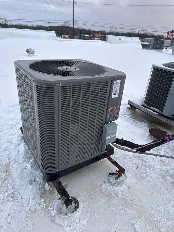 Successfully installed a complete Lennox HVAC system featuring a downflow furnace and rooftop air conditioning unit. Utilized lift equipment to safely position and mount the condenser on the snow-covered roof, securing it on proper supports with all necessary electrical connections and refrigerant lines properly installed.