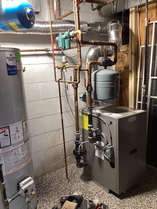 Performed annual boiler maintenance service, which included inspection of control unit, verification of operating parameters (digital display reading 181), and examination of gas valve assembly. System components including expansion tank, circulation pump, and copper piping were inspected and found to be in proper working condition. All connections were secure with no signs of leaks or malfunctions observed in the mechanical room setup.