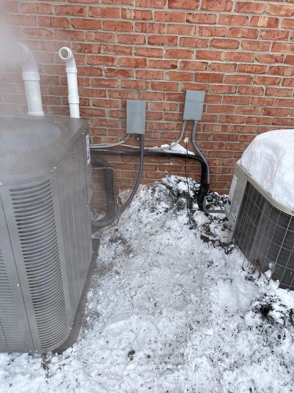 Completed installation of a comprehensive HVAC system including dual Lennox furnaces, an air conditioning unit, 50-gallon water heater, and two humidifiers. Properly installed outdoor AC condensing units against exterior brick wall with appropriate electrical disconnects, PVC piping, and necessary connections. Verified system operation in winter conditions, with units functioning as designed.