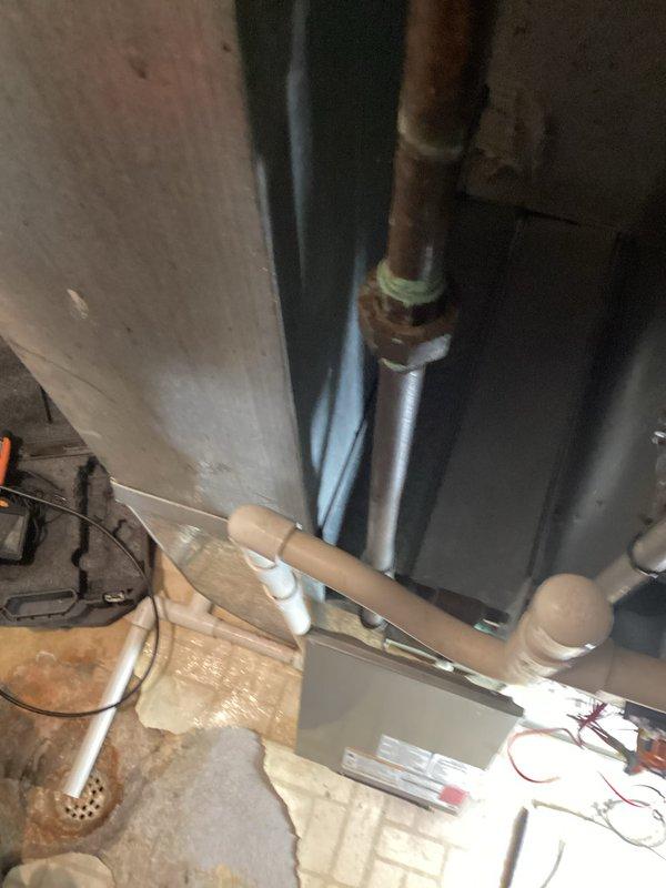 Conducted estimate for furnace replacement (model est9-11a). Visual inspection revealed existing water heater installation with proper ventilation and plumbing connections. Noted copper piping with valves and drainage system components that would need to be coordinated with new furnace installation.