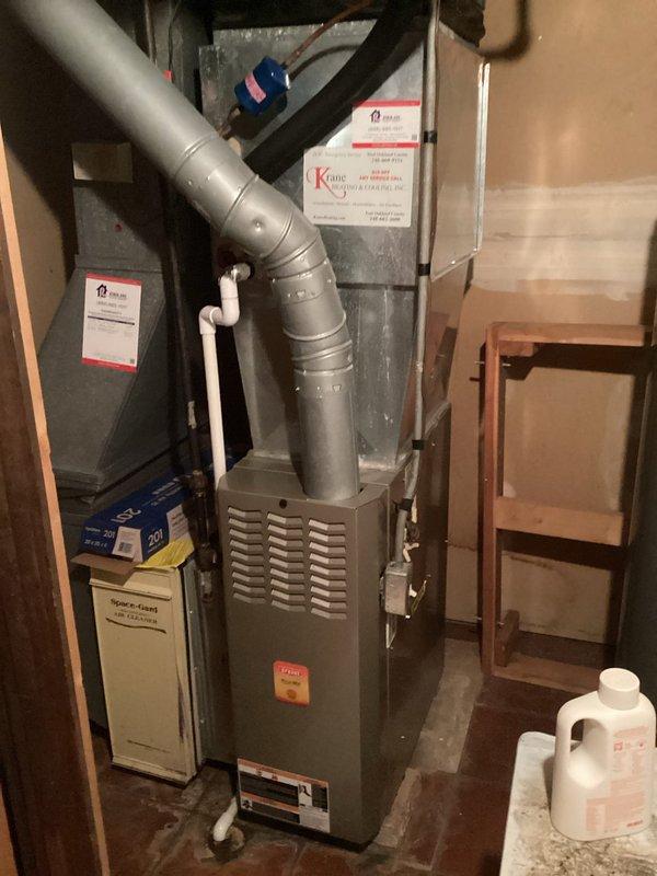 Conducted HVAC system replacement evaluation in residential basement utility area. Inspected existing furnace unit with connected ductwork and air handler component (Kane brand visible). Assessment included examination of installation space constraints, existing ductwork condition, and electrical connections for proper replacement specifications.