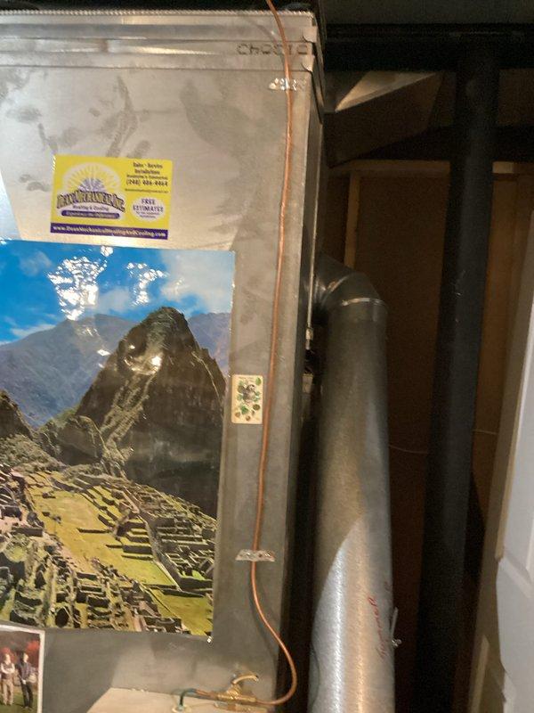 Conducted comprehensive evaluation of 19-year-old residential HVAC system for proactive replacement. Inspected existing basement installation including furnace unit with attached yellow tag and vertical air handler with PVC ventilation/drainage components. System assessment completed to provide appropriate replacement options for aging equipment before failure occurs.