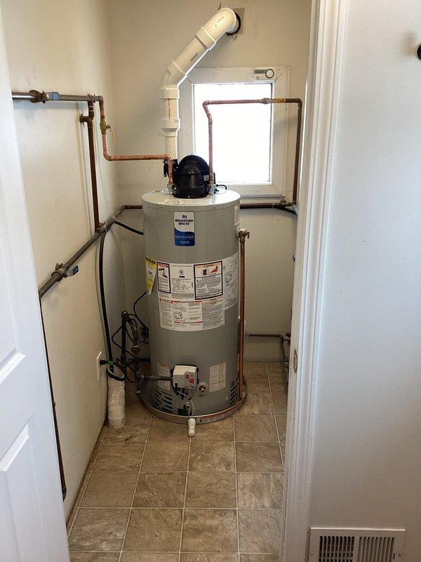 Successfully installed a new 40-gallon short water heater in residential utility closet. Completed all necessary copper pipe connections including supply lines and properly vented the unit with PVC vent pipe through exterior wall. System was tested and confirmed operational with all connections secure.