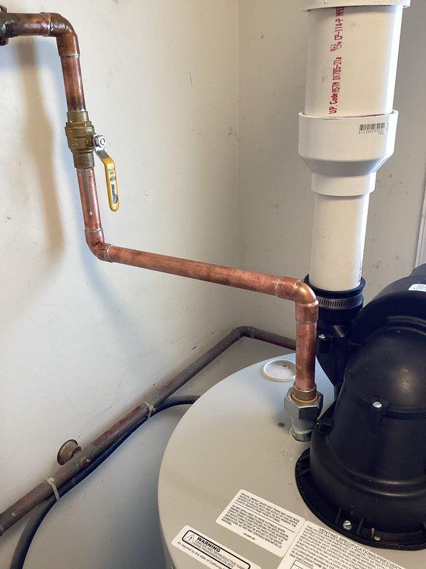Successfully installed a new 40-gallon short water heater in residential utility closet. Completed all necessary copper pipe connections including supply lines and properly vented the unit with PVC vent pipe through exterior wall. System was tested and confirmed operational with all connections secure.