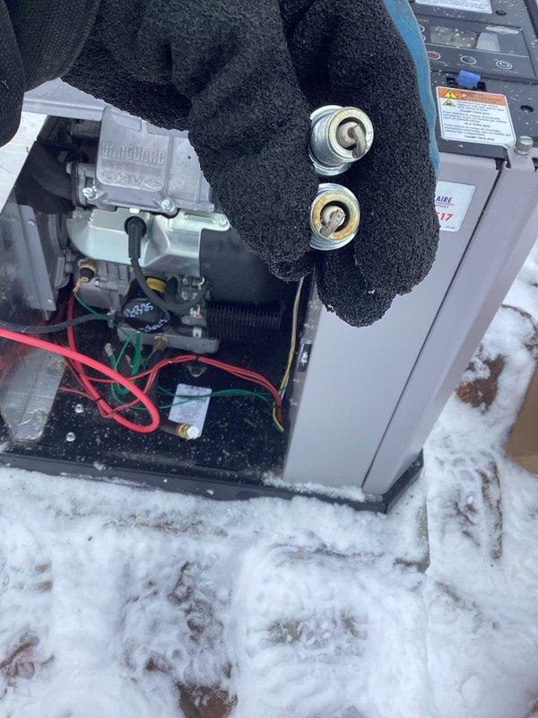 Performed scheduled generator maintenance service. Inspected and replaced spark plugs on Ultraguard unit. Noted significant frost and ice buildup on internal components including battery terminals and control mechanisms, which was addressed to ensure proper system operation.