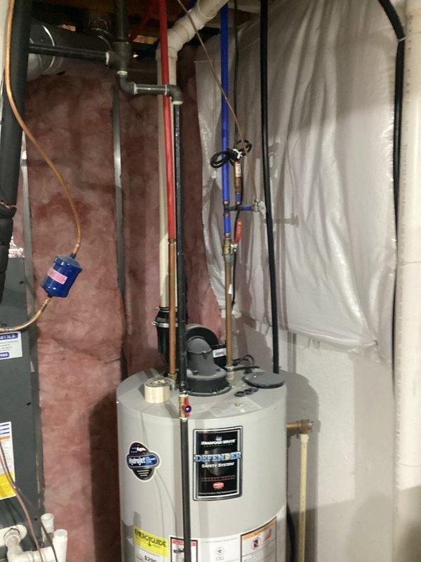 Completed replacement estimate for quote #03727-02 FRN. Documented existing water heater installation with associated plumbing connections and a furnace system with proper ductwork, PVC intake/exhaust venting, and electrical components. System is installed in a utility area with fiberglass insulation and appears to be in normal working condition.