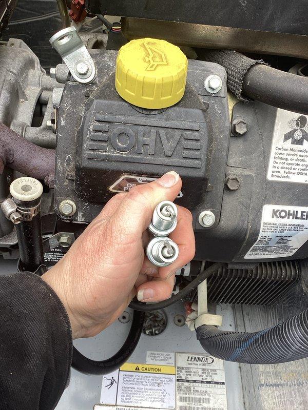 Completed annual maintenance service on Kohler residential generator. Performed spark plug inspection/replacement and checked oil levels. Unit appears to be in good working condition with normal operational wear.