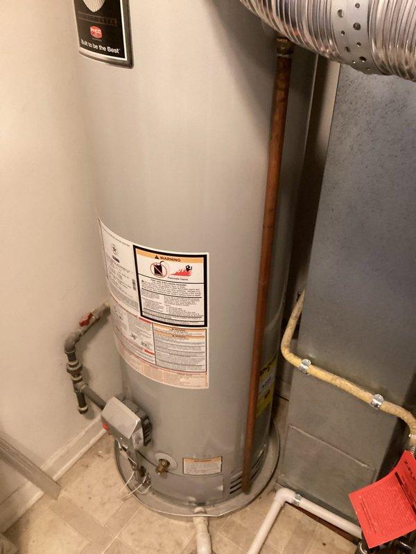Performed comprehensive inspection of Bradford White "Defender" water heater installation. System appears properly installed with appropriate ventilation via metal flue pipe, functional PVC and copper water connections, and operational shutoff valve. Water heater shows normal working condition with no visible damage or deterioration. All safety components intact and warning labels properly displayed.