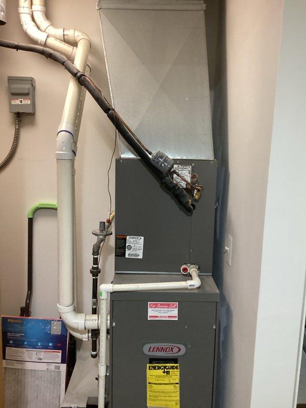 Completed estimate for full HVAC system replacement featuring a new Lennox furnace with appropriate ductwork connections. System includes properly installed white PVC venting/condensate lines, electrical connections, and refrigerant lines for the AC component.