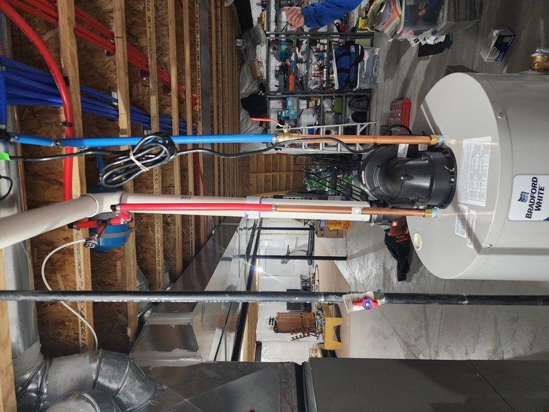 Successfully installed a 50-gallon Bradford White water heater in the customer's unfinished basement utility area. Completed all necessary plumbing connections using PEX piping system (red for hot water, blue for cold water) secured to joists, and ensured proper venting. Left the old tank on-site as requested for insurance inspection purposes.