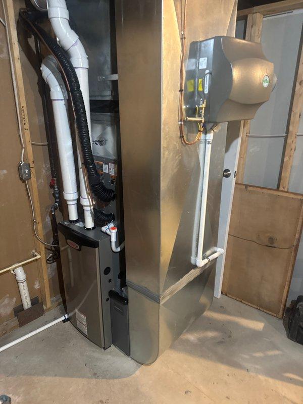 Successfully installed a complete HVAC system including a Lennox furnace with properly connected PVC intake/exhaust pipes, an air conditioning unit, S40 thermostat, and humidifier mounted to the ductwork. All components were professionally installed with appropriate connections to existing ductwork, electrical systems, and copper lines in the utility area, with the system fully tested and operational upon completion.