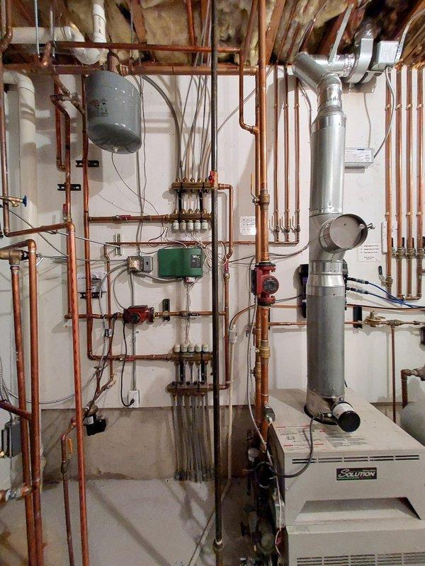 Responded to no hot water issue in residential mechanical room. Inspected Saunier-branded water heater system with associated copper piping network, expansion tank, circulator pump, valves and manifolds. Diagnosed and resolved the problem, restoring hot water functionality to the property.