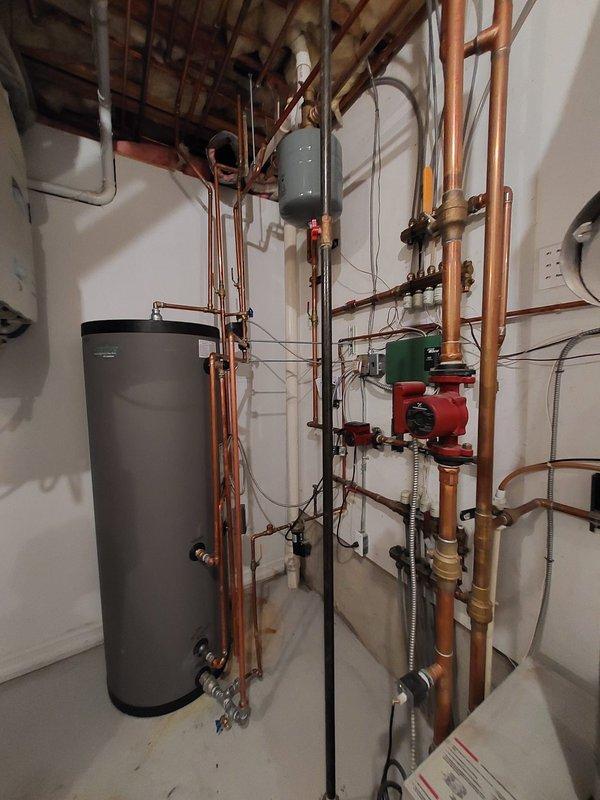 Responded to no hot water issue in residential mechanical room. Inspected Saunier-branded water heater system with associated copper piping network, expansion tank, circulator pump, valves and manifolds. Diagnosed and resolved the problem, restoring hot water functionality to the property.