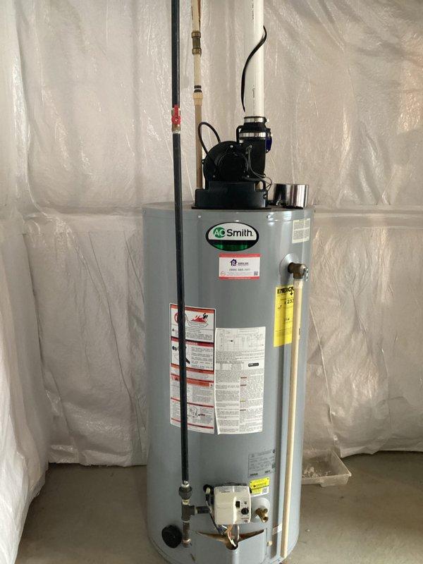 Conducted assessment of existing A.O. Smith tank-style water heater in basement for potential replacement with tankless system. Unit appears operational with standard connections including pressure relief valve, copper piping, and PVC venting. Customer expressed interest in tankless conversion options.