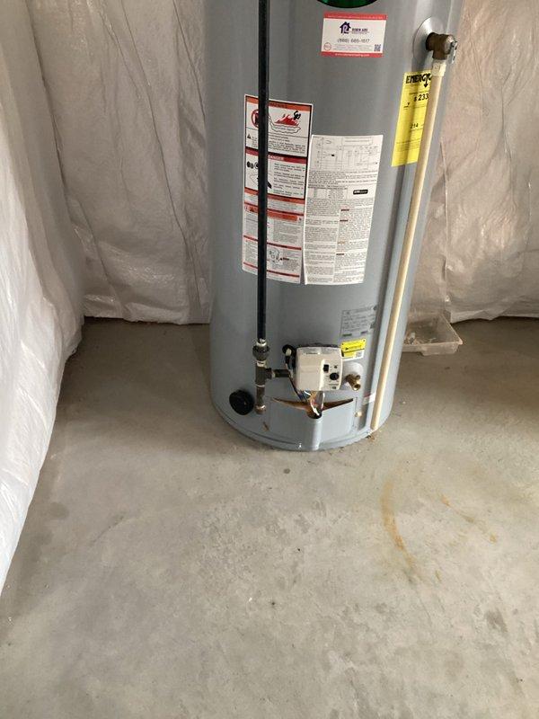 Conducted assessment of existing A.O. Smith tank-style water heater in basement for potential replacement with tankless system. Unit appears operational with standard connections including pressure relief valve, copper piping, and PVC venting. Customer expressed interest in tankless conversion options.