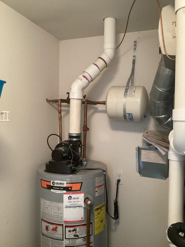 Conducted water heater inspection and found a cracked tank requiring replacement. Current State brand water heater installed in utility area shows significant tank failure with estimated 2-4 day replacement timeline. Documented existing setup including copper supply lines, PVC venting system, and wall-mounted expansion tank for proper replacement specifications.