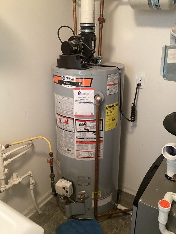 Conducted water heater inspection and found a cracked tank requiring replacement. Current State brand water heater installed in utility area shows significant tank failure with estimated 2-4 day replacement timeline. Documented existing setup including copper supply lines, PVC venting system, and wall-mounted expansion tank for proper replacement specifications.