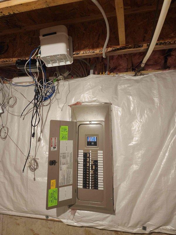 Completed site assessment for EV charger installation, evaluating electrical service panel capacity and configuration. Inspected main breaker panel with digital display meter, documented existing circuit layout, and determined available space for new dedicated circuit. Assessment confirmed suitable infrastructure for 240V Level 2 charging station installation with minor modifications to existing electrical system required.