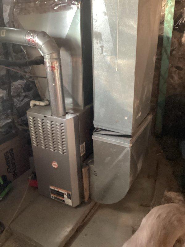 Conducted evaluation of existing residential HVAC system in basement utility area, which consists of an aging furnace with metal exhaust piping and outdated ductwork showing signs of wear. Documented current system configuration and measurements to prepare quote for complete replacement with new high-efficiency furnace and A/C unit, with special attention to proper sizing and compatibility with existing infrastructure.
