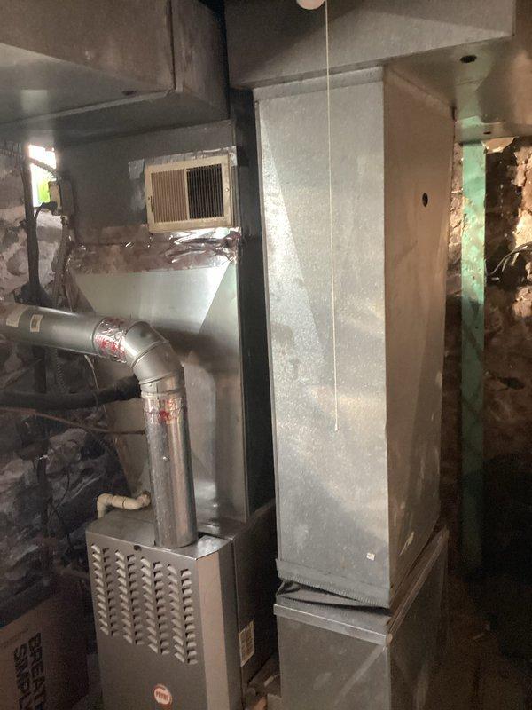 Conducted evaluation of existing residential HVAC system in basement utility area, which consists of an aging furnace with metal exhaust piping and outdated ductwork showing signs of wear. Documented current system configuration and measurements to prepare quote for complete replacement with new high-efficiency furnace and A/C unit, with special attention to proper sizing and compatibility with existing infrastructure.
