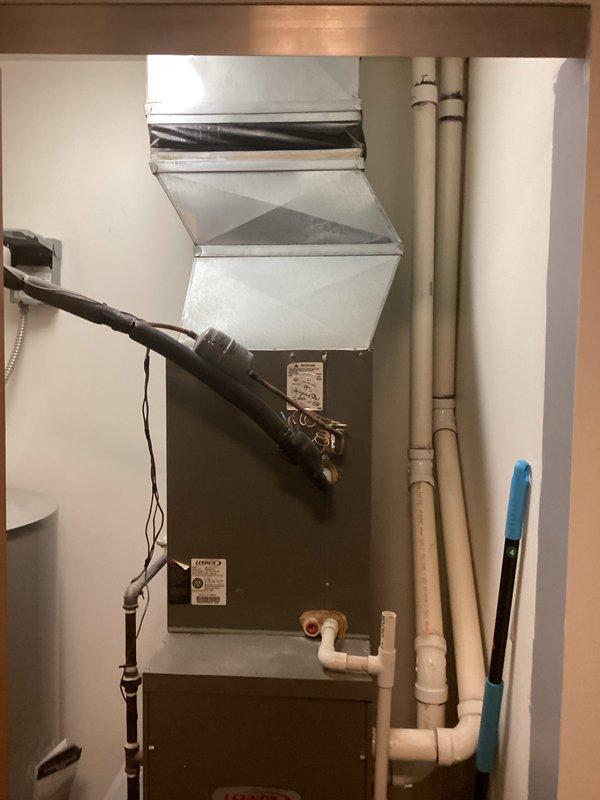 Conducted comprehensive evaluation of existing Lennox furnace system in utility closet. System includes standard furnace unit with metal cabinet, PVC ventilation/drainage pipes, and galvanized ductwork connections. Documented current installation configuration including electrical connections and condensate drainage system to prepare detailed replacement estimate.