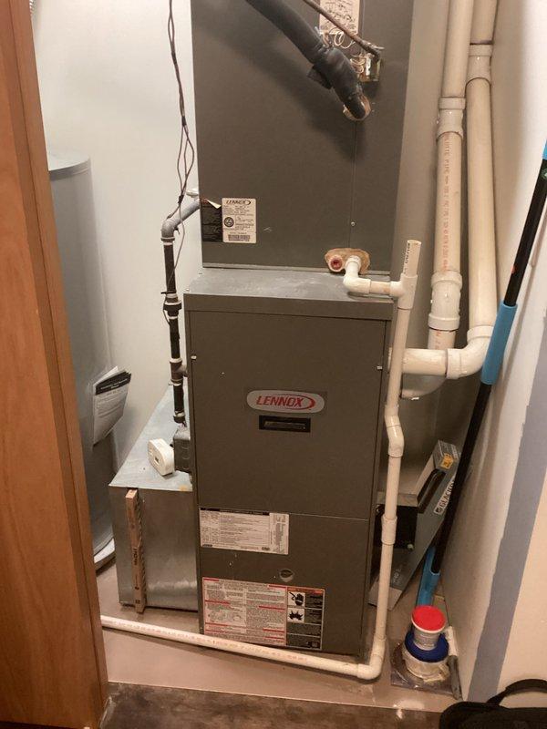 Conducted comprehensive evaluation of existing Lennox furnace system in utility closet. System includes standard furnace unit with metal cabinet, PVC ventilation/drainage pipes, and galvanized ductwork connections. Documented current installation configuration including electrical connections and condensate drainage system to prepare detailed replacement estimate.