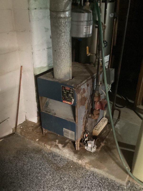 Conducted assessment of non-functional boiler requiring replacement. Inspection revealed significant corrosion, rust damage, and deterioration of the aging boiler unit installed in basement location, with visible issues affecting metal casing and connecting components. Documented condition of existing system including associated ductwork, plumbing connections, and control mechanisms to prepare comprehensive replacement estimate.