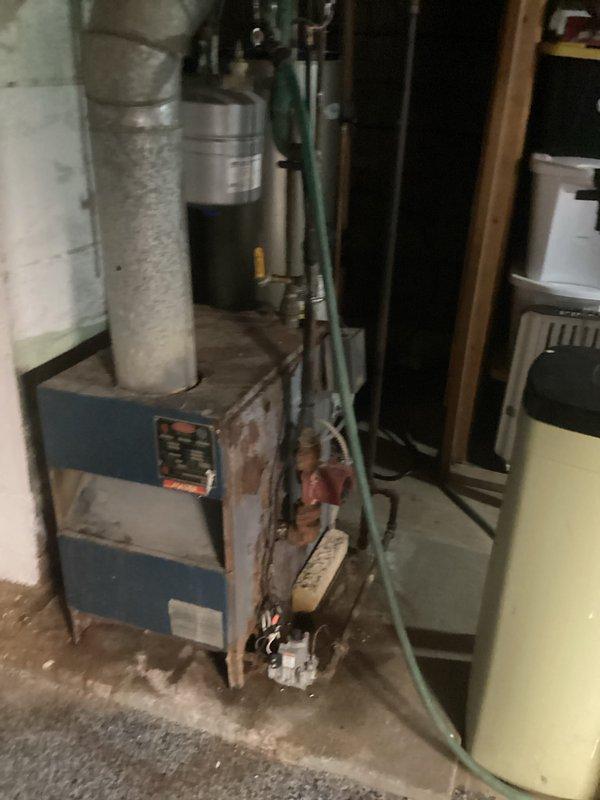 Conducted assessment of non-functional boiler requiring replacement. Inspection revealed significant corrosion, rust damage, and deterioration of the aging boiler unit installed in basement location, with visible issues affecting metal casing and connecting components. Documented condition of existing system including associated ductwork, plumbing connections, and control mechanisms to prepare comprehensive replacement estimate.