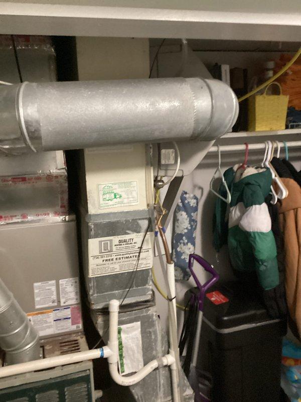 Completed HVAC system replacement estimate for a residential property, documenting the existing furnace unit with connected ductwork, PVC drainage, and ventilation components in a utility room that doubles as storage space. Photos were taken of the complete system installation showing the furnace with information labels, metal ductwork connections, and the overall configuration to support accurate replacement planning.