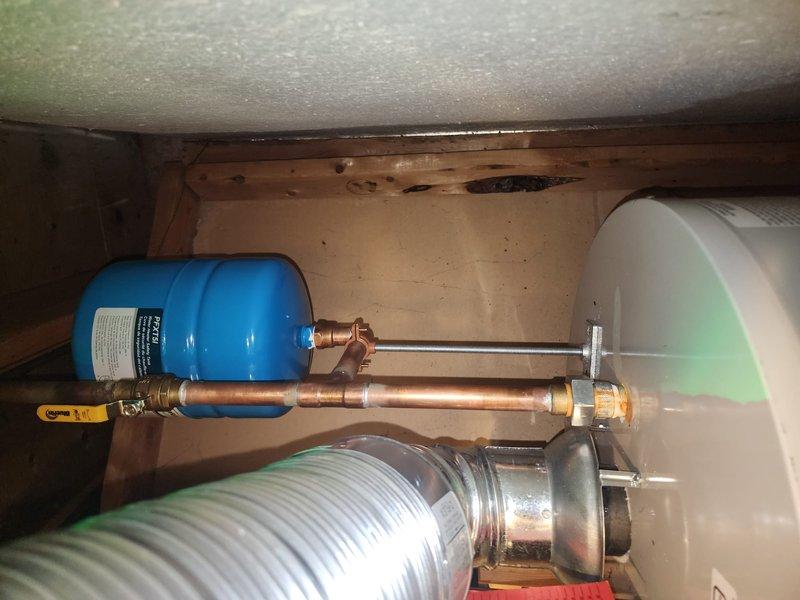 Conducted follow-up inspection on expansion tank installation. Verified proper mounting of the blue expansion tank connected to copper piping system with brass valve. Confirmed no leaks at connections and adequate support structure for the tank as per manufacturer specifications.