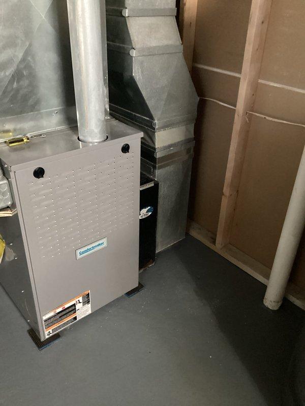 Completed HVAC replacement estimate for residential system located in utility/basement area. Existing installation includes galvanized metal ductwork with 90-degree bends, rectangular supply ducts, and a furnace unit with proper exhaust venting. Assessment included evaluation of current system configuration, ductwork condition, and installation requirements within partially finished space with exposed framing.