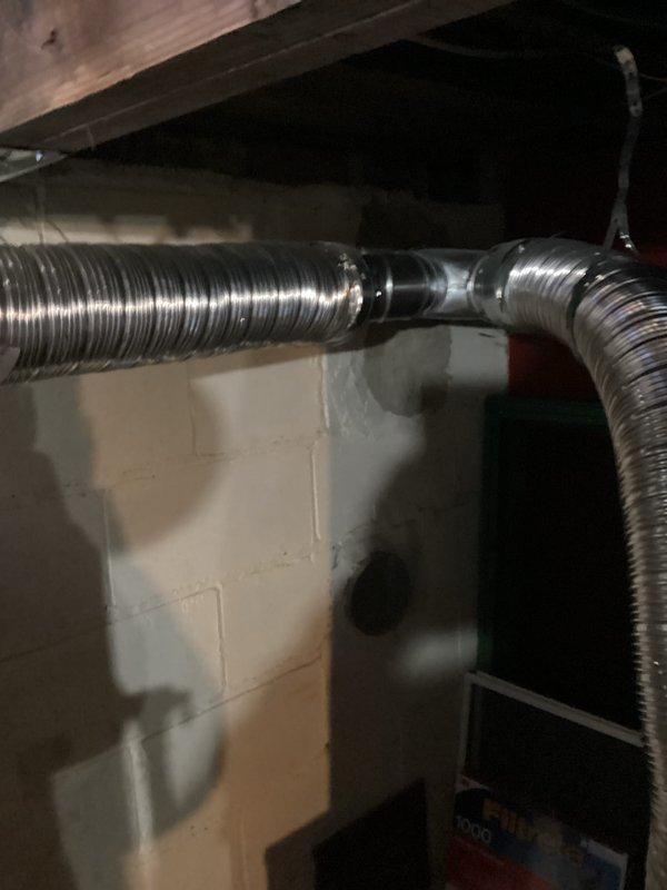 Conducted assessment of 12-year-old 40-gallon Bradford White water heater with Defender Safety System. Inspection revealed aging copper supply lines with patina development, properly installed expansion tank, and functional metal strapping securing components to ceiling joists. Also examined connected flexible metallic ductwork for proper ventilation.