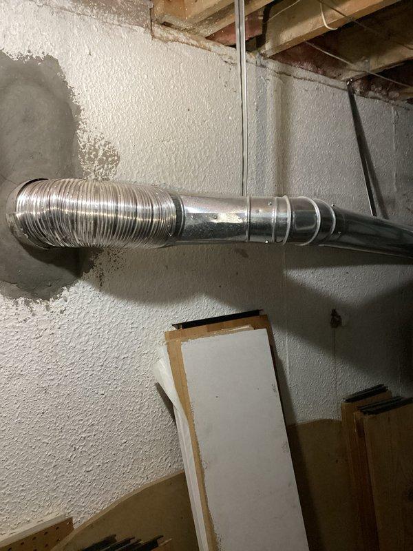 Conducted water heater replacement estimate in basement utility area. Inspected existing cylindrical white water heater with multiple black vent pipes and surrounding HVAC ductwork. Documented current installation configuration and space constraints for proper sizing and ventilation requirements of replacement unit.