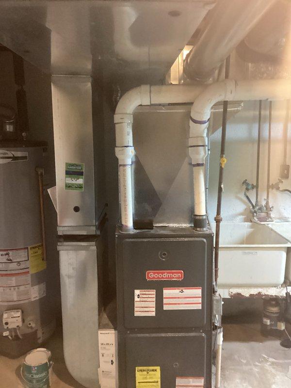 Conducted inspection of 10-year-old corroded HVAC system for replacement estimate. Current installation features a Goodman furnace with extensive ductwork in basement utility area, showing significant corrosion issues. Noted electrical concerns with multiple exposed wires running through ceiling joists that would need to be addressed during system replacement.