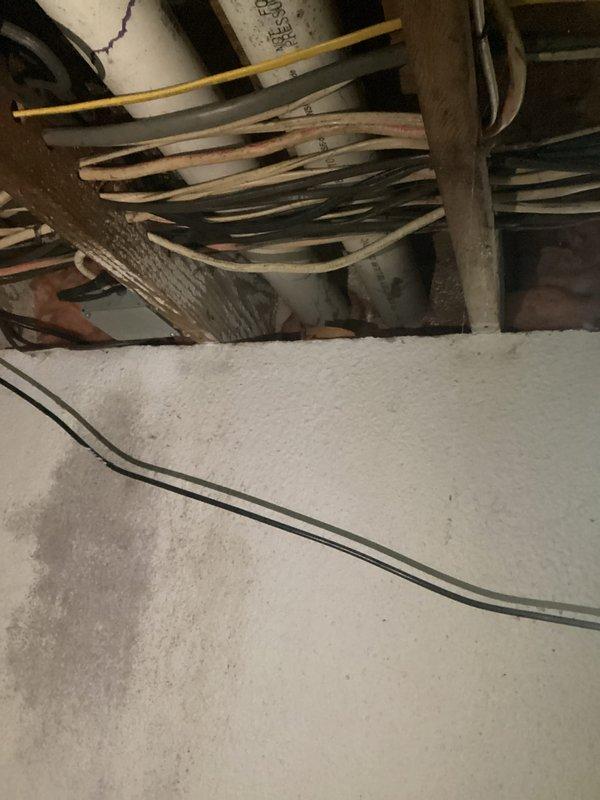 Conducted inspection of 10-year-old corroded HVAC system for replacement estimate. Current installation features a Goodman furnace with extensive ductwork in basement utility area, showing significant corrosion issues. Noted electrical concerns with multiple exposed wires running through ceiling joists that would need to be addressed during system replacement.