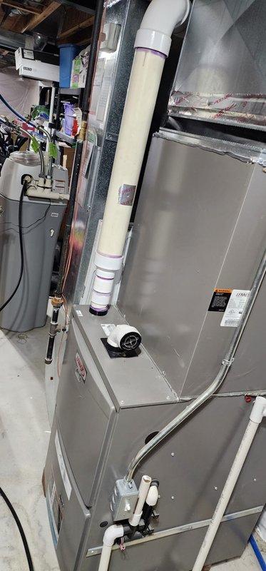 Performed routine maintenance on a forced air furnace system in basement utility area. Inspected all internal components including blower motor assembly, electrical connections, PVC venting, and control boards, confirming proper operation. System appears to be in good working condition with no issues identified during the Worry Free Service Agreement maintenance visit.