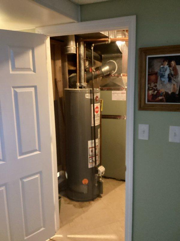 Conducted inspection of existing water heater system in utility room for replacement estimate. Examined copper supply lines, ventilation ducting, and shut-off valve functionality. Documented current installation configuration, noting aging components and potential upgrade requirements for proper ventilation and code compliance.